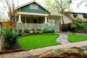 Well-maintained green lawn and landscaped garden in front of a house.