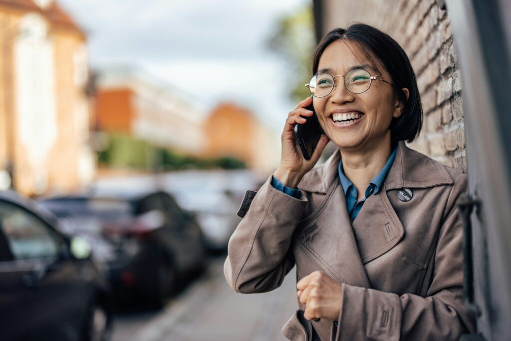 Excited woman having a phone call on a street.