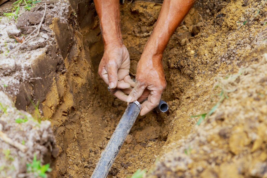 During the installation of the underground sprinkler system to water the garden in the yard, the man